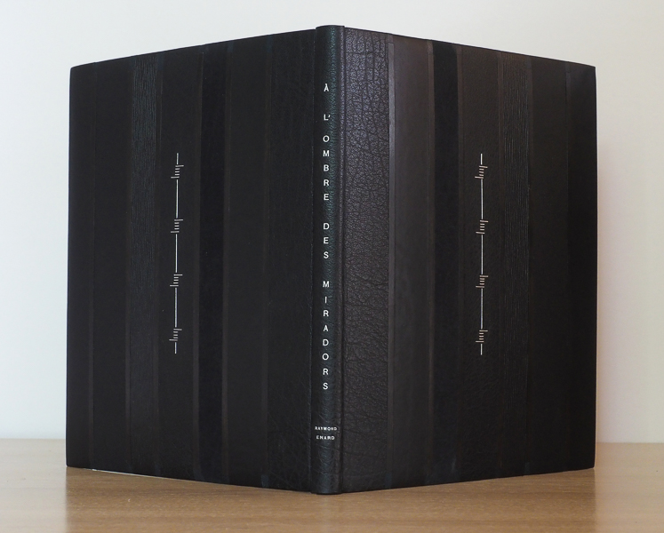 A l'ombre des miradors - Strates verticales de différent cuirs noir ( buffle sherpas et orégon, veau et chagrin) séparés par des baguettes d'ébène prolongées par des morceaux de peau oasis bleu nuit. Gardes intérieures bleu nuit. Dorure au Palladium de Stephane Gangloff.